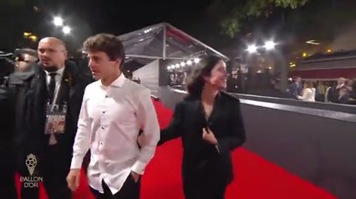 在球迷的歌声中 女友玛达莱娜挽着内维斯的手臂离开剧院