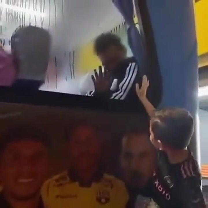 实拍：为了看清车外的孩子，梅西试图擦掉巴士车窗的水渍