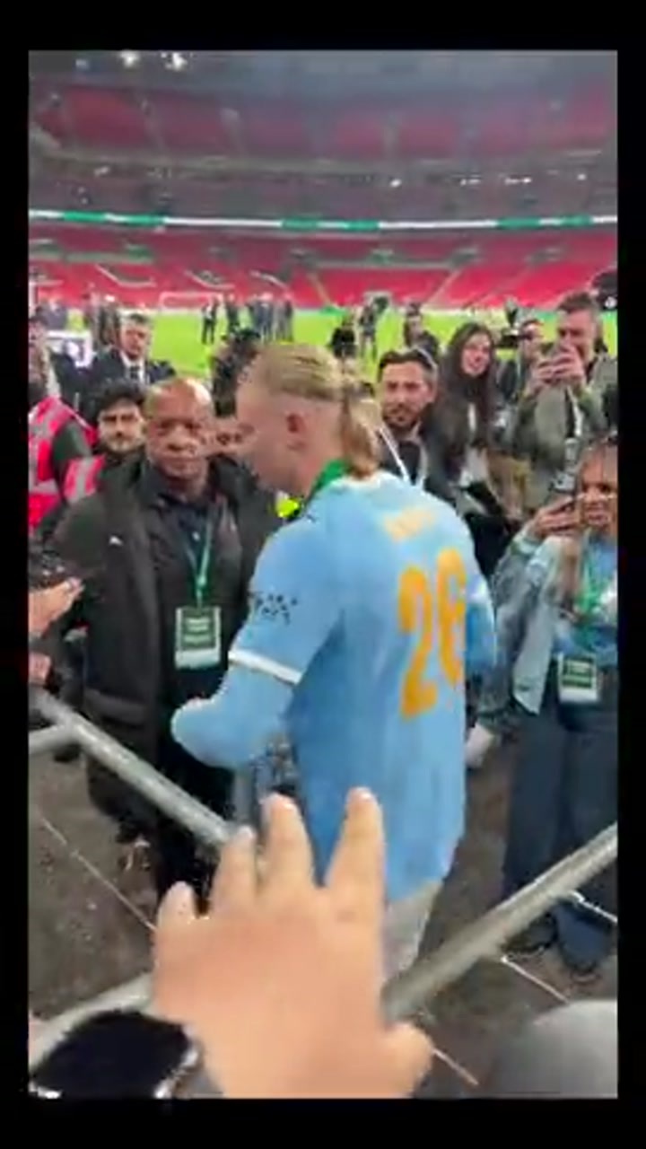 哈兰德手捧奖杯与球迷互动，意外遭球迷强吻